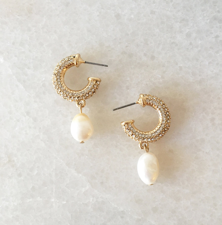 Gold crystal pave mini hoop with fresh water pearl charm drop earring on marble lay out