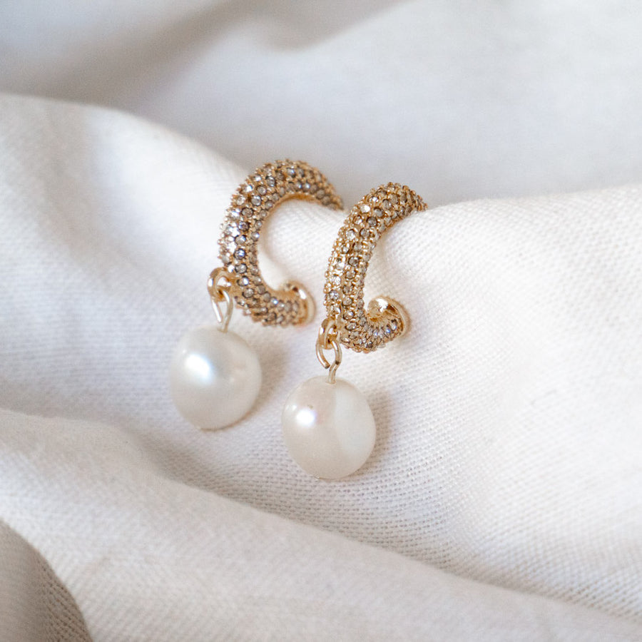 Gold crystal pave mini hoop with fresh water pearl charm drop earring on fabric still life